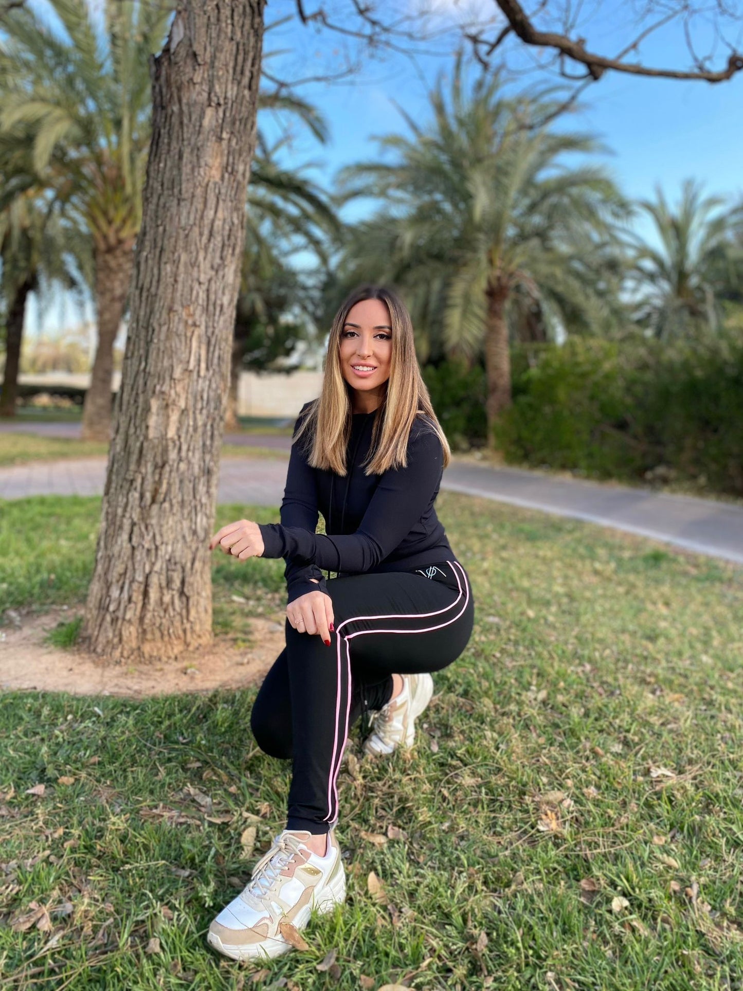 Blonde woman in a park wearing fitness clothing