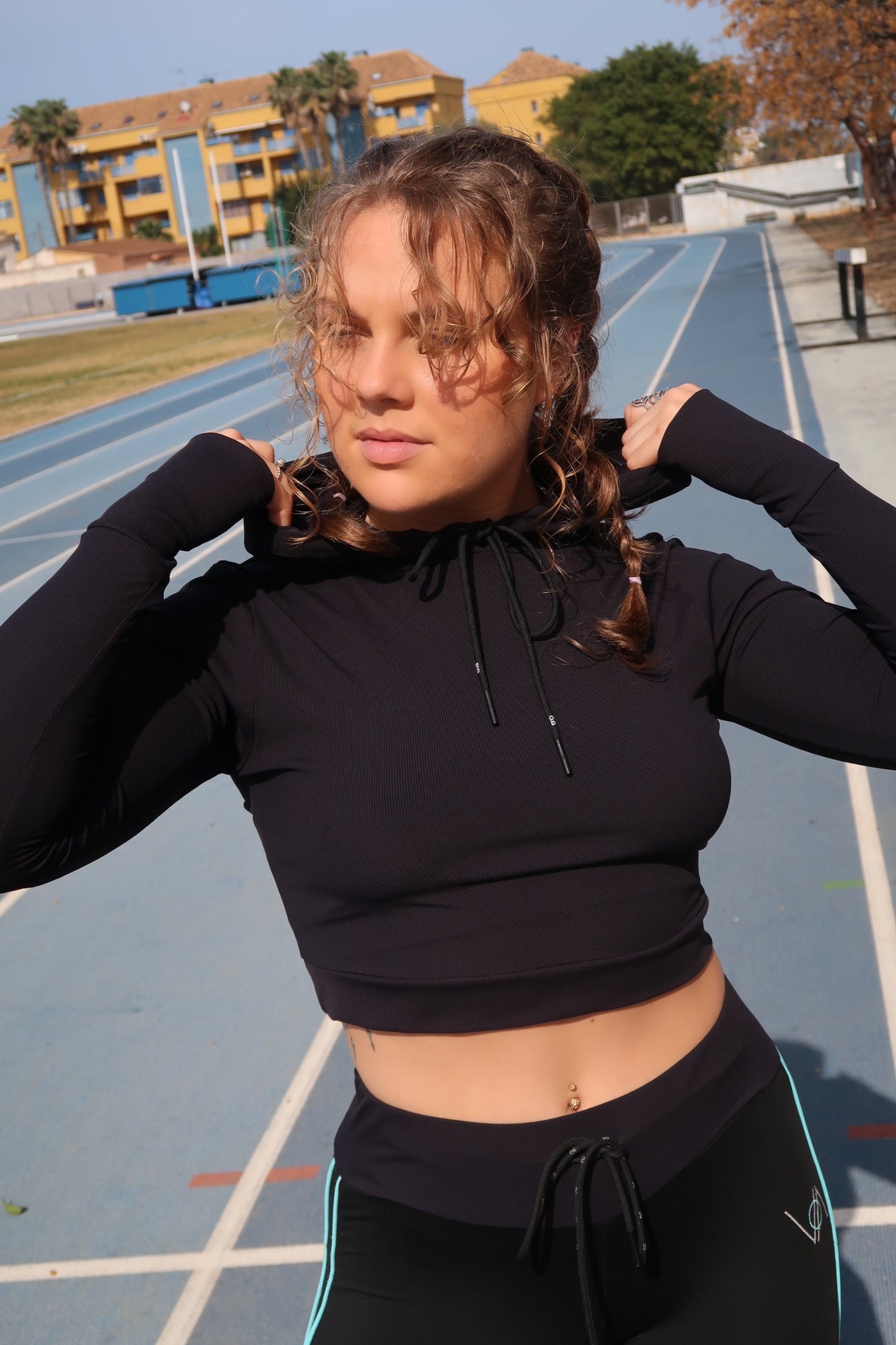 Girl with cropped hoodie holding hood